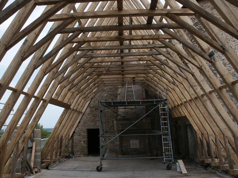 Charpente traditionnelle bois avec ferme centrale dans un bâtiment ancien par Pasquereau
