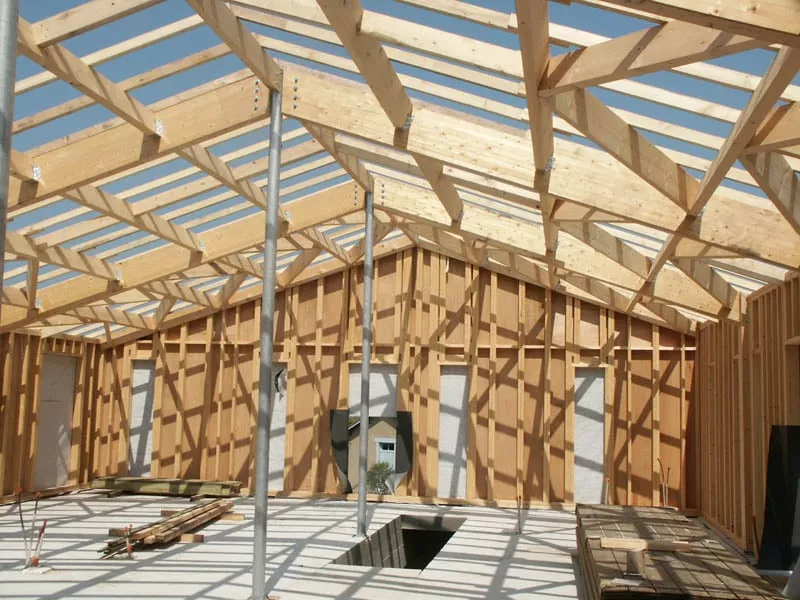 Charpente traditionnelle en bois en cours de pose dans une maison à ossature bois par Pasquereau
