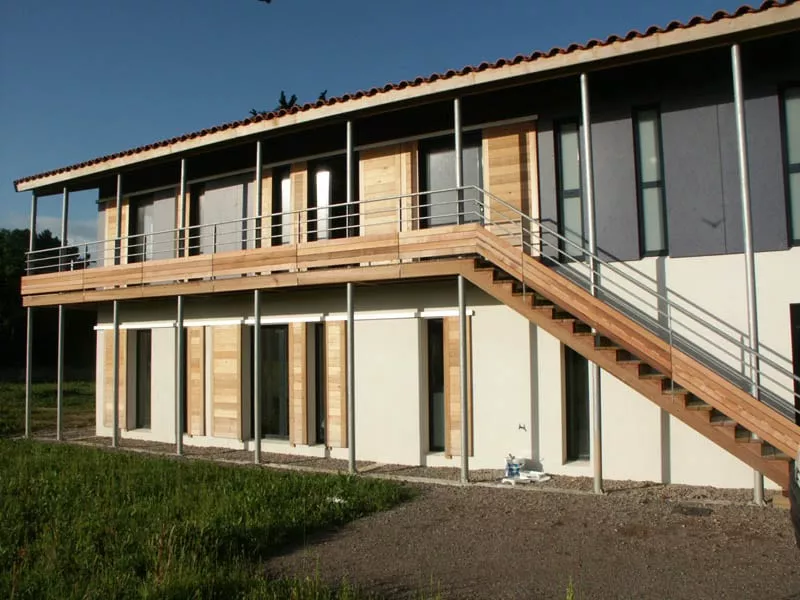 Maison à ossature bois avec bardage et escalier extérieur réalisée par Pasquereau